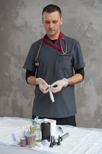 Veterinarian in scrub suit prepares medical equipment with precision and care.